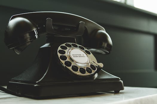 pexels photo 1416530 1416530 Classic black rotary phone on hotel reception desk, evoking nostalgia and vintage charm.